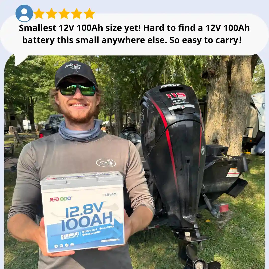 A man outdoors holding a Redodo 12.8V 100AH ultra mini battery